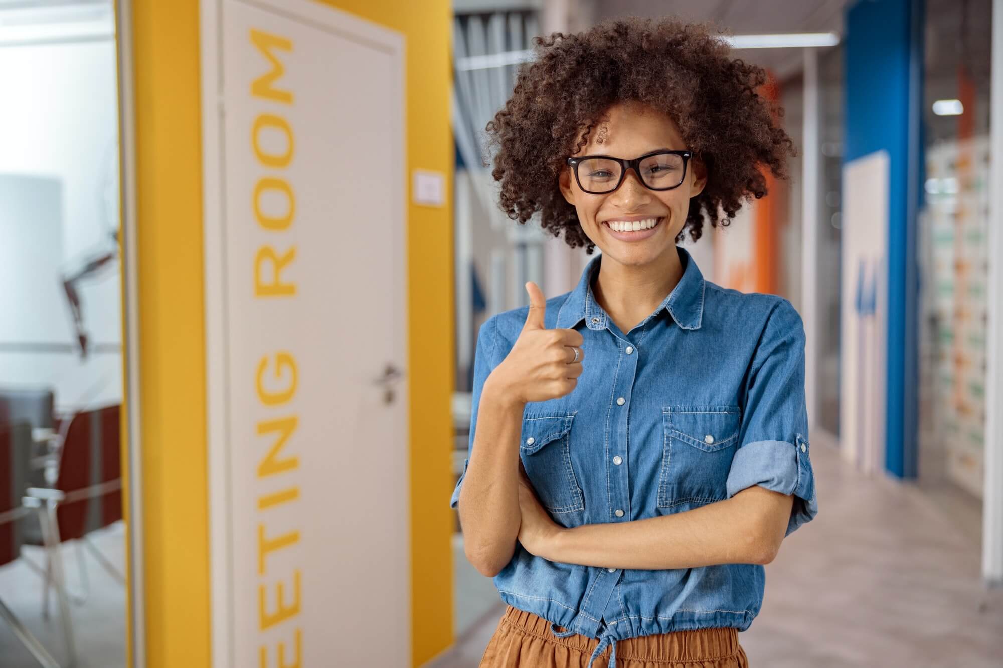 multiethnic-young-lady-holding-thumb-up-in-coworking.jpg